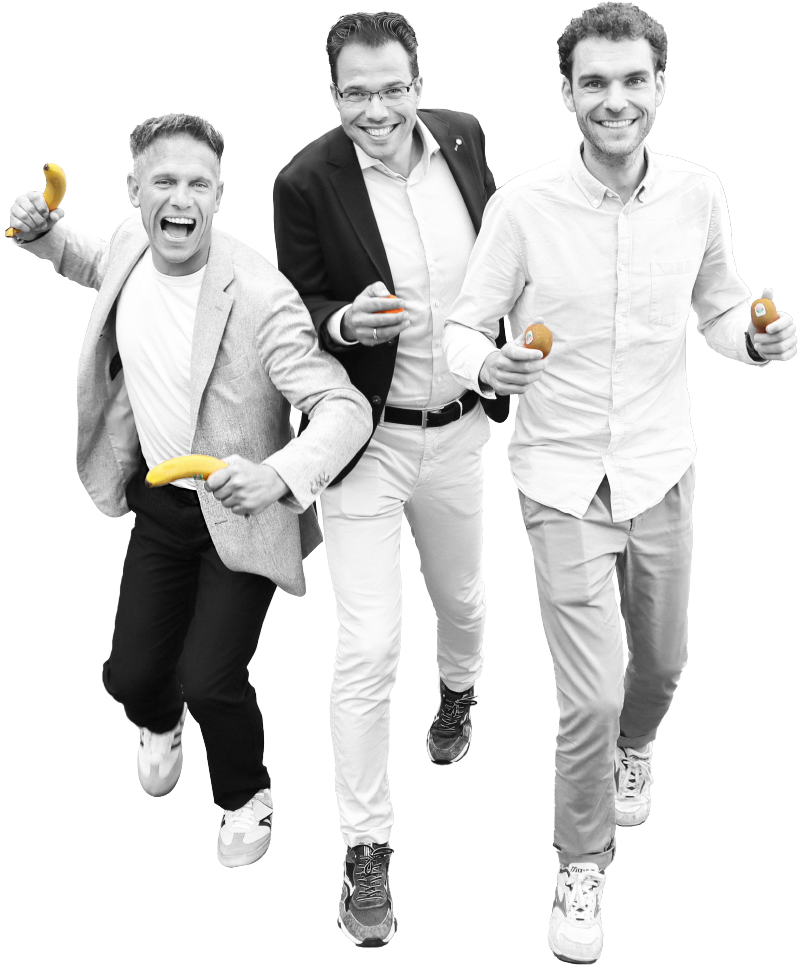 Drie lachende mannen lopen naar voren met bananen, sinaasappels en kiwi’s