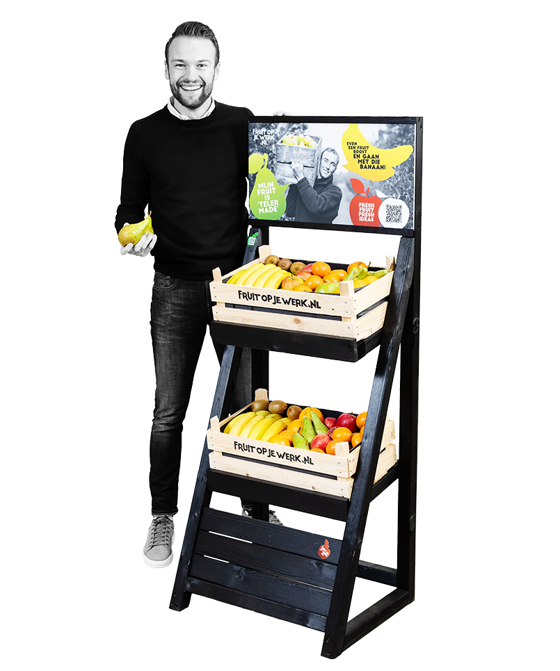 Medewerker van FRUIT OP JE WERK naast een fruitdisplay met twee gevulde fruitkisten